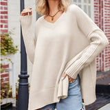 Beige women's oversized batwing poncho sweater in XL, modeled with sunglasses, showcasing fall fashion with a focus on the shoulder and neck areas.