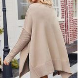 Beige women's oversized batwing poncho sweater worn by a woman in fall fashion, accessorized with sunglasses and stylish shoes, highlighting the casual and trendy outerwear look.