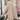 Beige women's oversized batwing poncho sweater worn by a woman in fall fashion, accessorized with sunglasses and stylish shoes, highlighting the casual and trendy outerwear look.