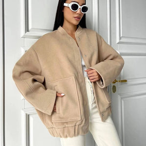 Beige women's oversized fleece bomber jacket with long sleeves, showcasing trendy winter fashion.