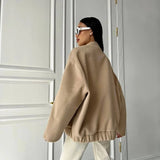 Beige women's oversized fleece bomber jacket with trendy winter fashion design, featuring a prominent collar and long sleeves.