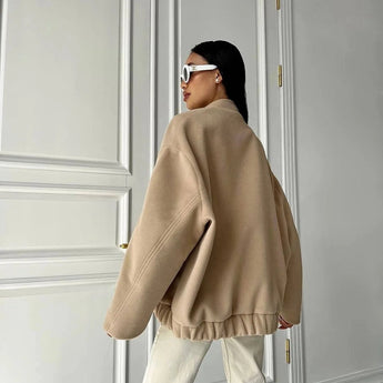 Beige women's oversized fleece bomber jacket with trendy winter fashion design, featuring a prominent collar and long sleeves.