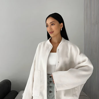 Beige oversized fleece bomber jacket for women with a trendy winter fashion design, featuring a collar and long sleeves, styled in the White XL variant. The model with black hair is showcasing the jacket, highlighting its casual yet fashionable appeal.