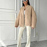 Beige women's oversized fleece bomber jacket with a trendy winter fashion design, featuring a cozy collar and long sleeves, worn by a model accessorized with sunglasses.