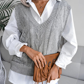 Beige women's V-neck cable knit vest worn over a white dress shirt, showcasing a casual preppy style with intricate knit patterns, suitable for layering.