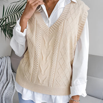 Beige women's V-neck cable knit vest layered over a white dress shirt, showcasing a casual preppy style. The vest features a classic cable knit pattern, designed for comfortable and stylish layering.