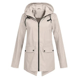 
A beige women's waterproof hooded raincoat in the apricot color variant, size 2XL, featuring a stylish design with a collar, button closures, and long sleeves.