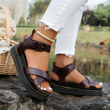 
A pair of women's chunky platform sandals in burgundy red, featuring multiple straps, designed for summer wear. The sandals are displayed on a model's feet, highlighting the fashion-forward design and elevated sole.