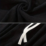 Black corduroy cargo pants made from durable cotton featuring a soft drawstring, displayed in a well-lit studio setting.