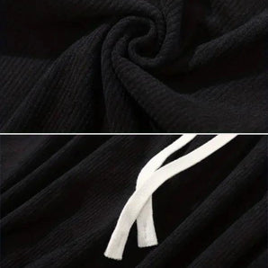 Black corduroy cargo pants made from durable cotton featuring a soft drawstring, displayed in a well-lit studio setting.