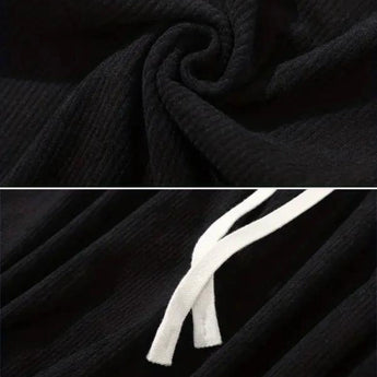 Black corduroy cargo pants made from durable cotton featuring a soft drawstring, displayed in a well-lit studio setting.