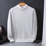 An elegant men's black crewneck sweater featuring a distinct white collar, displayed on a clothes hanger. The sweater is in a gray shade, with long sleeves, suitable for a formal or casual look.