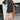 Black denim dress paired with a fringe purse and western ankle boots, styled for a fashionable look. The dress is knee-length with sleeves, and the set is complemented by the boots that have a distinct Western flair.