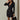 Black double-breasted V-neck blazer dress for women in a formal style, featuring long sleeves and tailored waist, modeled by an individual standing.