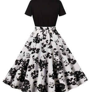 Black floral A-line midi dress featuring a vintage-inspired design, perfect for cocktail events, with a fitted waist, short sleeves, and a modest neckline.