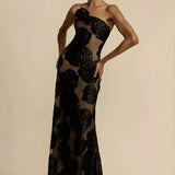 Black floral sheer one-shoulder evening dress displayed on a mannequin, highlighting its elegant design with a floral pattern, asymmetrical neckline, and sheer fabric.