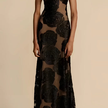 Black floral sheer one-shoulder evening dress displayed on a mannequin, highlighting the dress's elegant asymmetrical design with a sheer fabric that features a floral pattern, showing the shoulder, arm, and waist details.