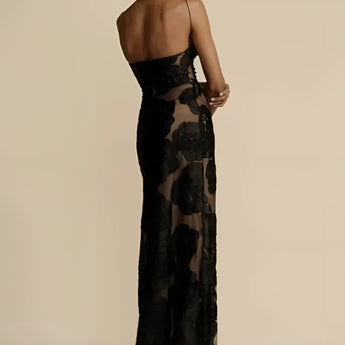
A black floral sheer one-shoulder evening dress featuring elegant floral patterns, showcasing a fitted waist and a flowing gown design.