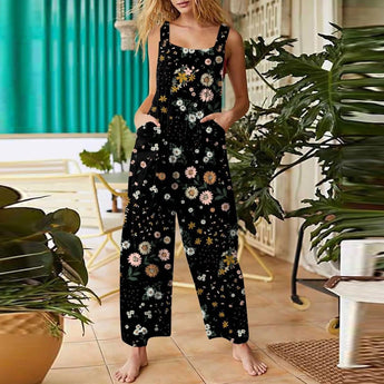 
A woman wearing a black floral sleeveless jumpsuit, showcasing a casual summer style with pockets, standing and emphasizing the shoulder, waist, and thigh areas.