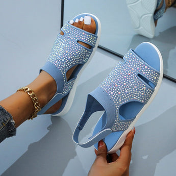 Black glitter rhinestone sandals in size 42, featuring a flat design with blue accents held by a person's hand.