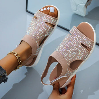 Brown size 42 sandals with black glitter rhinestones on a flat sole, shown on a foot with manicured nails.