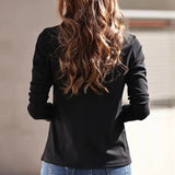 Black and green V-neck blouse with long sleeves, suitable for both office and casual wear, worn by a standing person.