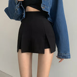 Black high-waist pleated mini skirt worn with a white top, showcasing an elegant day-to-night fashion style.