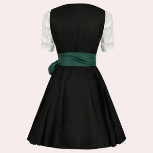 A black vintage cocktail dress featuring lace sleeves and a contrasting green sash, designed with a fitted waist and a formal collar.