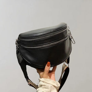Black leather fanny pack with multiple zippers, designed as a trendy waist bag with an adjustable strap.