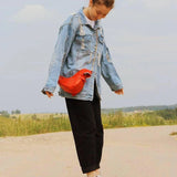 Black leather horse-shaped crossbody bag with a gold chain strap.