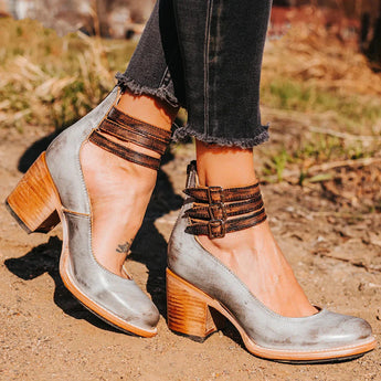 Black chunky heel ankle strap Mary Jane shoe made of leather in gray, size 43, worn on a person's foot standing on grass outdoors.