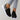Black leopard print women's stylish comfortable sneakers shown on a person wearing jeans, highlighting the shoe's design, pattern, and sporty, casual appeal.