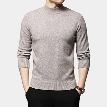 Black wool turtleneck sweater for men, slim fit, worn by a model with a khaki outfit, showcasing winter fashion style. Model's arm is visible with a watch, suggesting a polished look. Sweater is the centerpiece of the image.