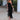 Elegant black off-shoulder evening gown with tiered fringe detailing, showcasing a luxurious designer style.