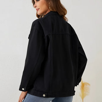 Woman wearing a black oversized denim jacket with cropped design, showcasing casual streetwear fashion.