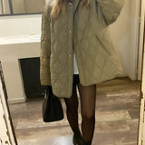 Black oversized quilted jacket for women, designed as a lightweight urban puffer, featuring long sleeves and a quilted pattern.