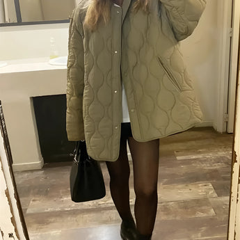 Black oversized quilted jacket for women, designed as a lightweight urban puffer, featuring long sleeves and a quilted pattern.