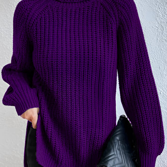 
A woman wearing a purple oversized ribbed turtleneck sweater paired with black jeans. The sweater is cozy and suitable for winter, featuring a high neck design.