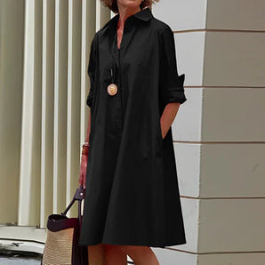 
A black oversized women's midi shirt dress featuring a collared neckline and long sleeves, styled for elegant urban fashion in a 2XL size.