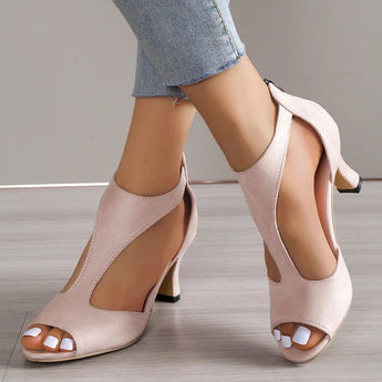 Beige peep-toe heels with a low heel, worn by a model, displaying the shoe's comfortable fit and summer style.