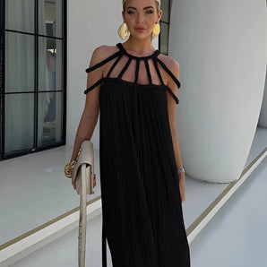 
A woman wearing a black pleated maxi dress designed for elegant evening wear, featuring long sleeves and a fitted waist. The dress is styled for a sophisticated look in a Nero color and size L-XL.