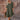 
A woman wearing a knee-length green ruffle dress with short sleeves. The dress is a casual, one-piece garment with a fitted waist, suitable for everyday wear. The woman is standing, showcasing the dress's style and fit.