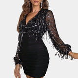 Black sequin party dress featuring a sheer beaded blouse, open back design, and short sleeves.