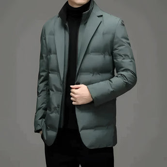A modern men's formal jacket in green, featuring a slim fit and double-breasted design. The blazer has a structured collar, long sleeves, and multiple buttons. It is styled over an electric blue dress shirt, showcasing the blazer's sophisticated and polished look.