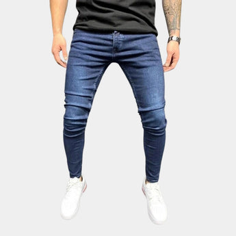 Dark blue stretch skinny jeans for men, featuring a slim fit and trendy urban style, highlighting the waist and thigh areas with a comfortable denim material.