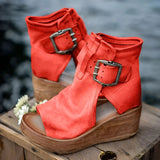 Black suede wedge sandals with high platform and buckle, featuring a boho chic design.