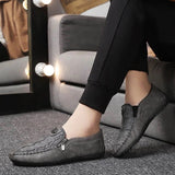 Black textured leather slip-on loafers with a zipper for men, displayed on a gray background, highlighting the sleek design and comfortable fit suitable for dress occasions.