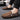 Men's black slip-on loafers made of textured leather, featuring a zipper detail, displayed on a white background and designed for a stylish and comfortable fit.