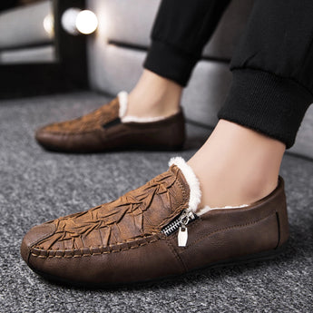 Men's black slip-on loafers made of textured leather, featuring a zipper detail, displayed on a white background and designed for a stylish and comfortable fit.