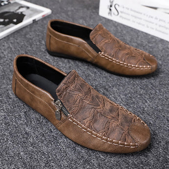 Black textured leather slip-on loafers for men with a decorative zipper, showcasing a sleek and modern design, ideal for a stylish and comfortable dress shoe option.